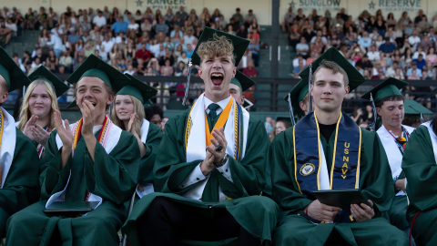 FILE - Ethan Myers, center, and Ian Franks, left, yell after a name was announced as graduates received their diplomas during Estacada High School’s graduation ceremony on June 13, 2026. On-time high school graduation is one of the education indicators the Annie E. Casey Foundation report uses to calculate child well-being in Oregon.