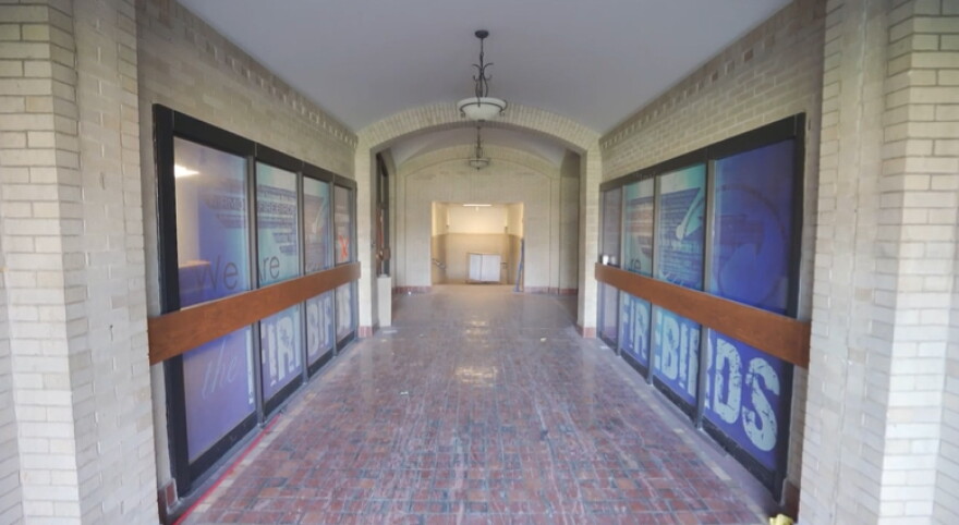 The hallway of the Barnes building with windows on the left and right featuring the blue Kettering Fairmont logo.