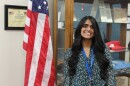Peoria's new election commissioner Jessily Joseph stands in front of American flag
