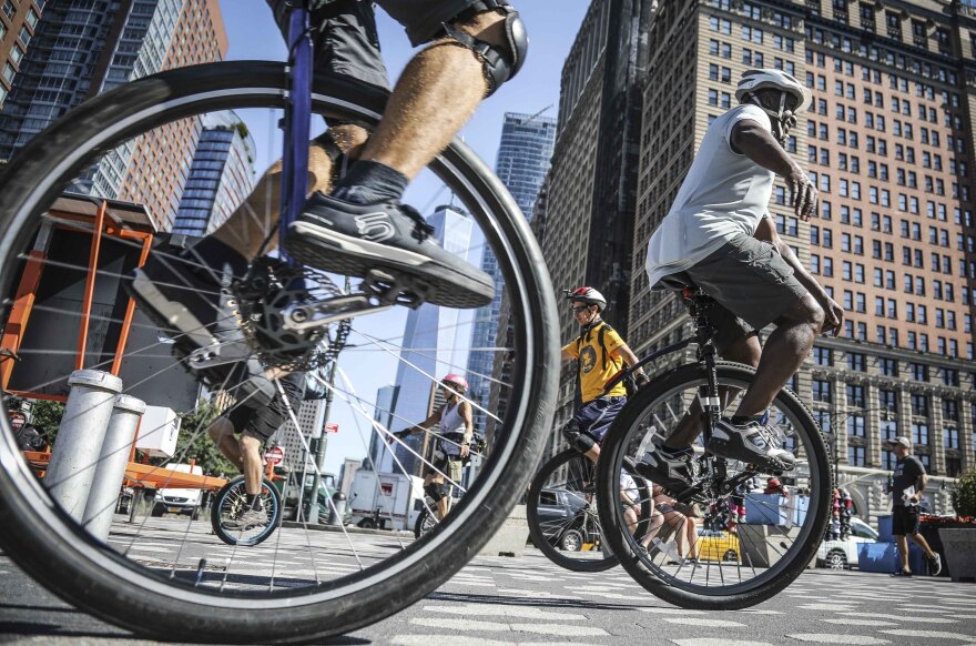 Close shots of people riding unicycle with New York City buildings in the background