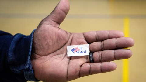 Sasha Dix holds his, "I voted," sticker after voting at T.C. Roberson High School on Election Day, Nov. 5, 2024, in Asheville, N.C.