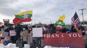 A group of people in winter clothing and anti-Covid masks hold a red banner declaring "thank you, Mr. President." Another sign is in the shape of Myanmar and patterned after the country's flag.