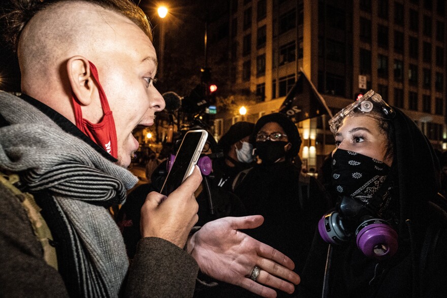 A counter protester has a debate with a Trump supporter. She asks him to leave as he walked through the crowd of counter protesters.