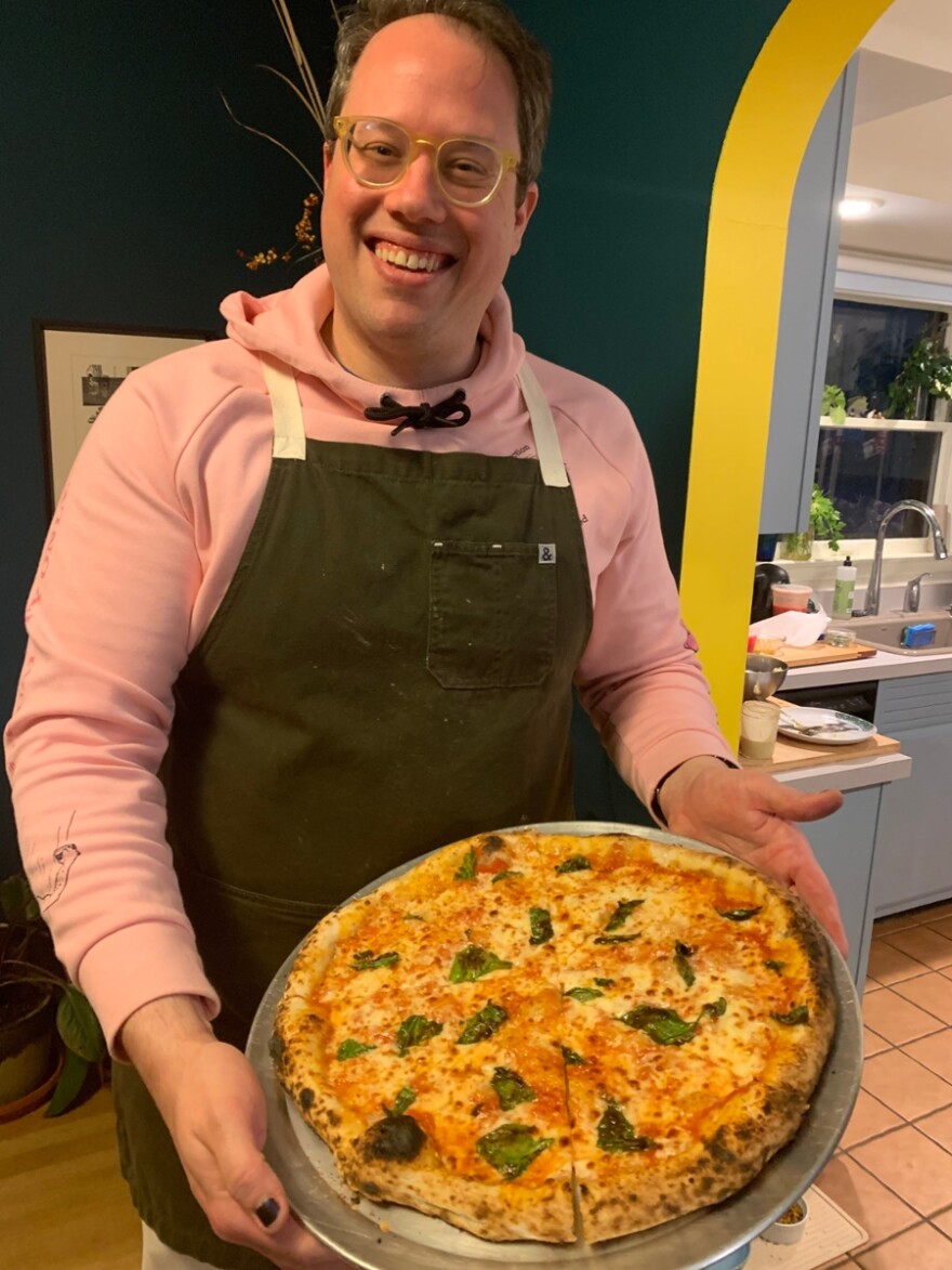 Pete Giordano shows off a modified pizza margherita fresh from the outdoor pizza oven.