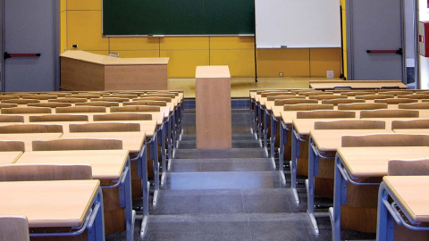 Rows of desks are empty in a college classroom.
