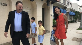Jeff Greene, left, is all smiles as he arrives at the Palm Beach Central Fire Station to vote Tuesday morning. He came with his wife, Mei Sze, right, and the couples' three sons.