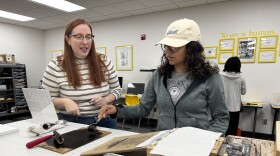 Katie Lanning, an associate professor of English at Wichita State University, helps a student use a Book Beetle machine, which mimics a full-size Gutenberg press. A new Book Technologies Lab at WSU was funded by a donation from Lanning's family in honor of her late grandfather, Robert L. Cattoi.