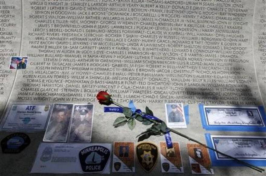 In this May 13, 2013 file photo, a rose is placed at the wall with the names of fallen police officers at the National Law Enforcement Officers Memorial in Washington during the National Police Week