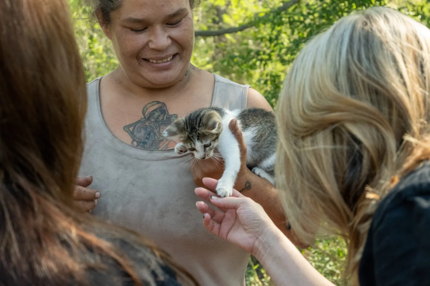 Shawna, who camps near Chapin Park, grins as one the volunteers greets her kitten, Lamina. She told The Journal that this is her first summer braving the heat without a home.