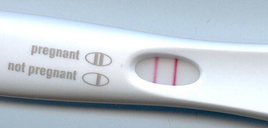 A white pregnancy test with two pink bars showing a positive test.