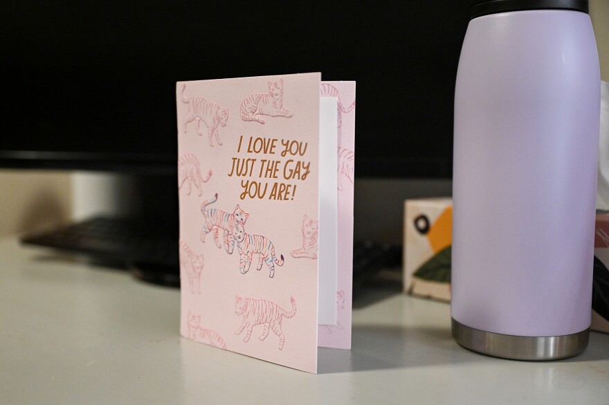 A card reading “I love you just the gay you are,” sits on Kennedy Robbins’ desk on Thursday, March 14, 2024, at her home in Columbia. “I was really nervous about coming out to my parents, especially my dad. I wasn’t sure how they’d react or if they’d accept it,” Robbins said. “Now, that card is my reminder that I’m loved by my parents no matter what. I don’t have to be afraid to be myself. He got me that card completely unprompted for Valentine’s Day and will often grab pride-related items or tell me about different pride-related things he sees while he’s out. It’s really nice to be supported by my dad in that way. I know not everybody is as lucky as I am to have that.”