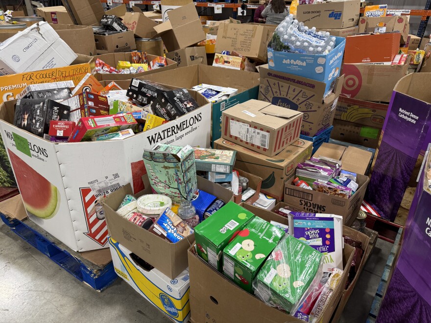Multiple pallets of food rest on the floor of a warehouse