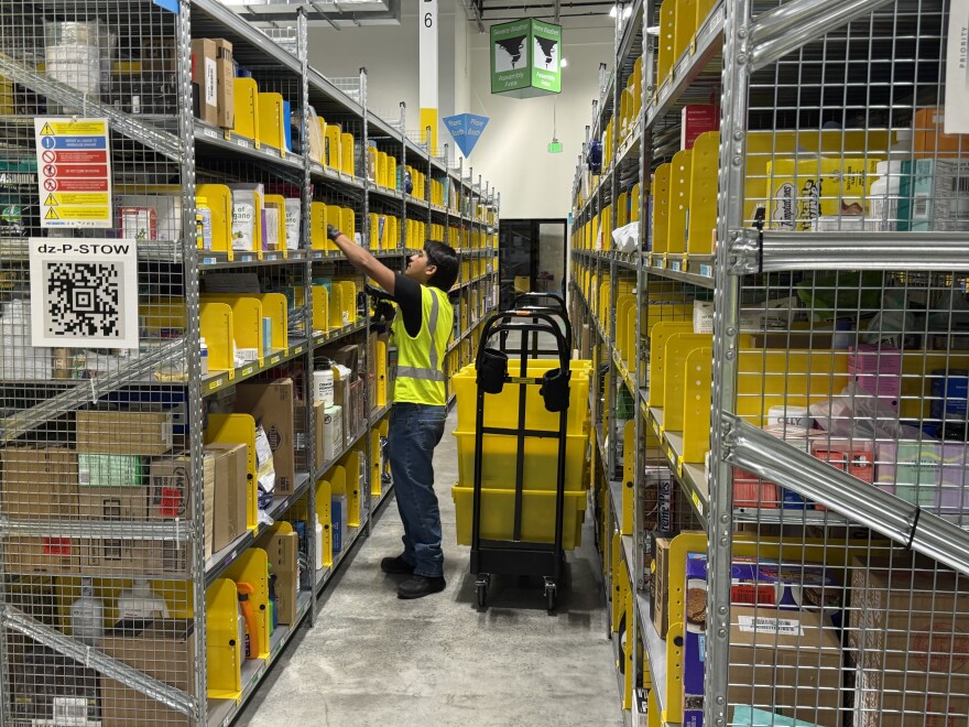 An unidentified employee at the Amazon delivery station in Yuma prepares an order.