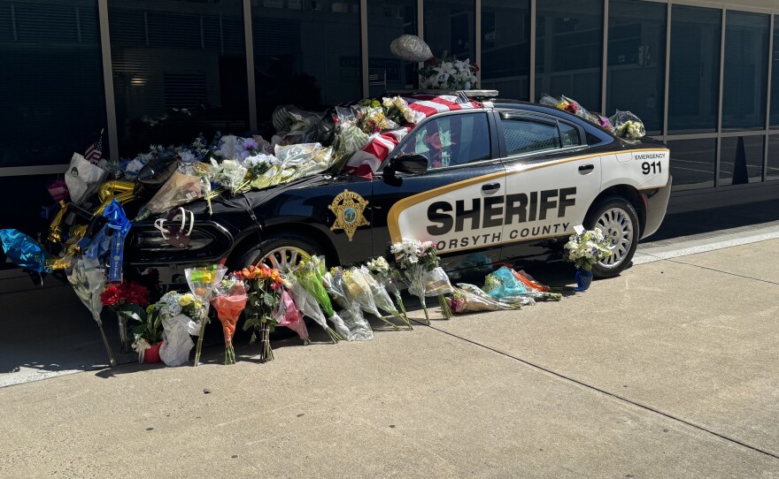 A photo of a Forsyth County Sheriff's vehicle decorated with flowers to honor Deputy Kaleb Mitchell