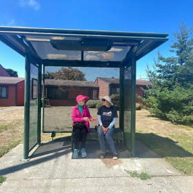 Two Humboldt County residents wait for public transit at a local bus stop.