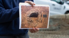 Benjamin Ford, principal of Rivanna Archaeological Services, holds up a photo of an old well discovered during the study.