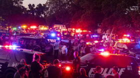 Emergency vehicles flash their lights at 9 p.m. along Lamont Avenue to honor Kalamazoo County Sheriff Deputy Ryan Proxmire outside the Sheriff office in Kalamazoo, Mich., Sunday, Aug. 15, 2021. A deputy in Michigan has died after being wounded during a chase with a gunman. The Kalamazoo County Sheriff’s Office says Deputy Ryan Proxmire died Sunday. Deputies encountered the suspect Saturday evening at a gas station in Galesburg and a chase ensued.