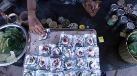 In India, the centuries-old tradition of chewing betel leaves, or <em>paan</em>, spread with spices and sweeteners is losing popularity. In this file photo from 2006, an Indian shopkeeper arranges silver foils of <em>paan </em>at his roadside shop in New Delhi.