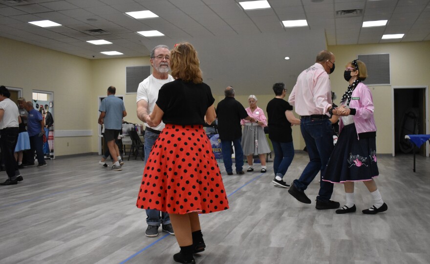 Becky Tompson and her husband (center) wait for the caller’s cue to start dancing. (Kennedy Lerner/WUFT News)