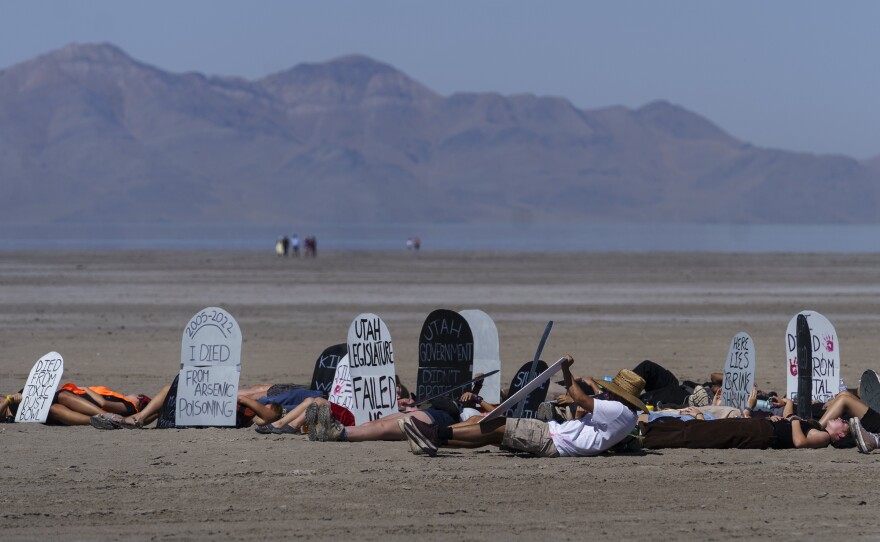 Students lie on dry lakebed at Great Salt Lake, with cutout tombstones.