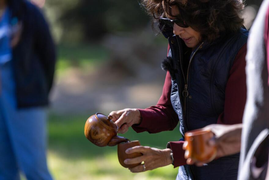 Dr Susan Abookire serves birch tea to close a forest therapy session at Harvard's Arnold Arboretum. (Jesse Costa/WBUR)