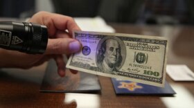 This $100 bill was previously a $5 bill, as evidenced by its security thread glowing blue under a UV light. A real $100 bill’s