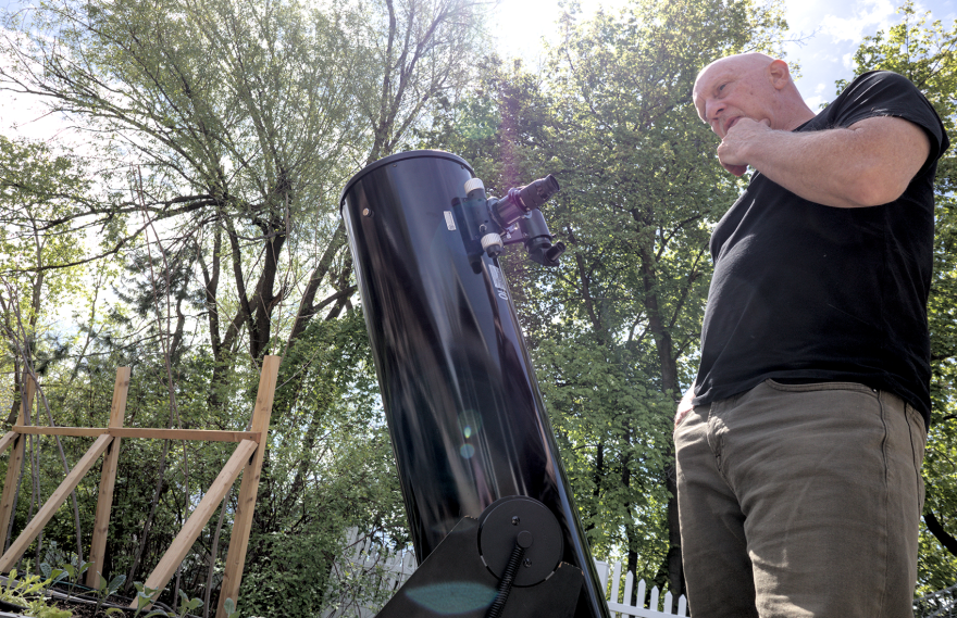 A person looks at a large telescope.