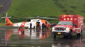 Coast Guard and emergency medical personnel transfer patients from an Air Station Kodiak MH-60 Jayhawk helicopter to an ambulance in Kodiak, Alaska, June 2, 2016. The helicopter crew responded to a report of a fire at the Park’s Cannery near Uyak Bay on Kodiak Island. U.S. Coast Guard photo.