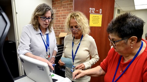 Left to right: Democratic Deputy Registrar of Voters Sharon Fiarman, Democratic Registrar of Voters Deborah Greenberg, and Republican Registrar of Voters Francesca Signore, test a tabulator, a machine that counts paper ballots at Westport Town Hall on July 21, 2026.