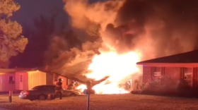 A residential house on fire as first responders attempt to control the fire.