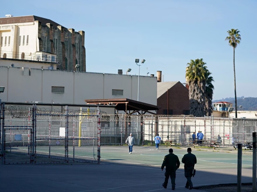 A pair of correctional officers walk through the exercise yard at San Quentin State Prison in San Quentin, Calif., Friday, March 17, 2023.