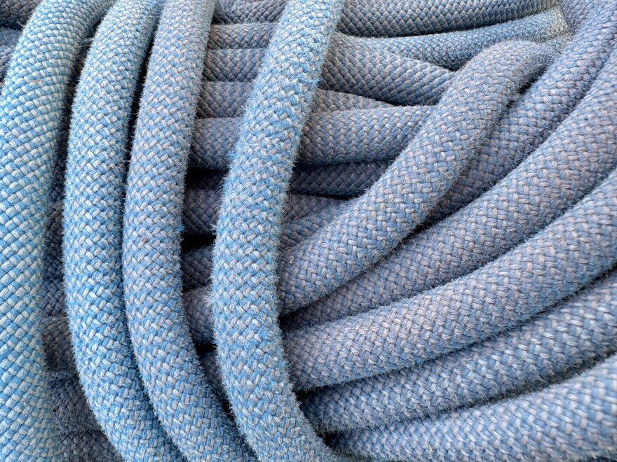 A close-up of the strands of an older blue climbing rope.
