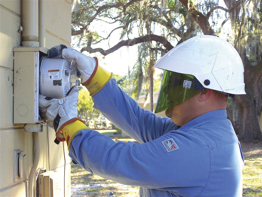 An LCEC worker checks a electrical meter.