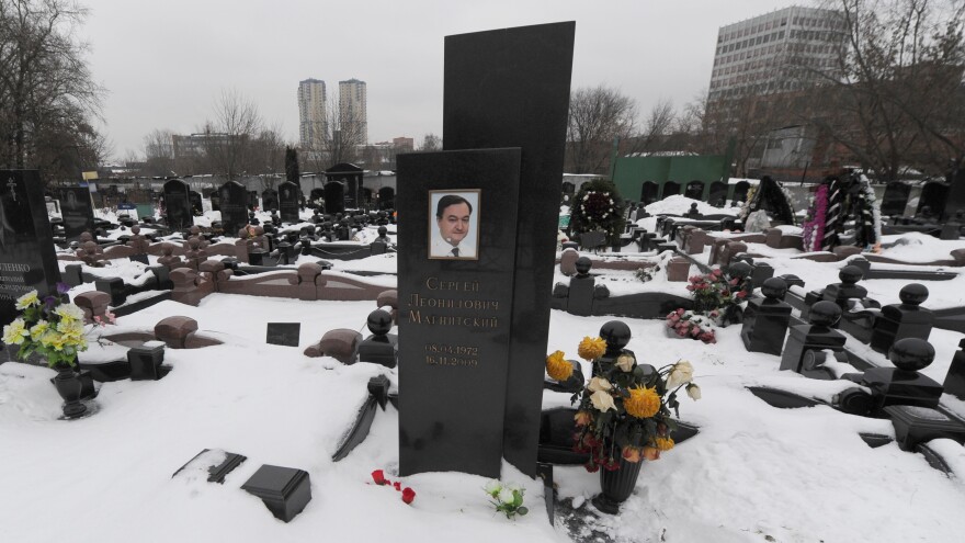 A picture taken on December 7, 2012, shows the snow-clad grave of Russian lawyer Sergei Magnitsky with his portrait on the tomb at a cemetery in Moscow.