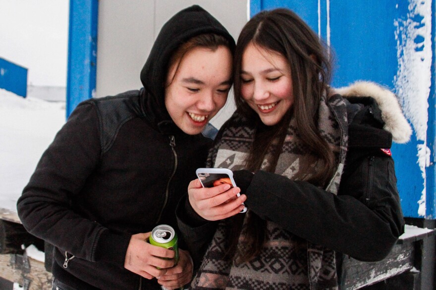 Eino Taunajik and Kamilla Larsen watch a music video during a break from the suicide prevention course in Tasiilaq.