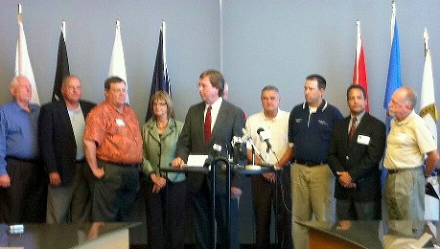 Mayor Bartlett, flanked by other elected and appointed officials, announces the lawsuit.