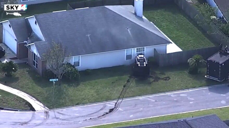 A Jacksonville SWAT vehicle is seen smashing out a window early Wednesday on Copper Springs Road and firing what appears to be tear gas inside.