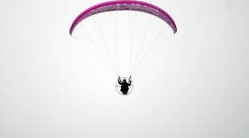 Jake Hutzler flies his paramotor in a clear sky.