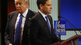 Donald Trump passes behind Marco Rubio during a commercial break in Thursday's Republican presidential primary debate at Fox Theatre in Detroit. All of the candidates Thursday said they would stand behind Trump if he is the eventual GOP nominee.
