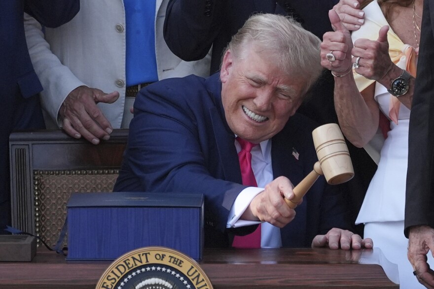 President Donald Trump bangs a gavel presented to him by House Speaker Mike Johnson  after he signed his signature bill of tax breaks and spending cuts at the White House, Friday, July 4, 2025, in Washington. (AP Photo/Evan Vucci)