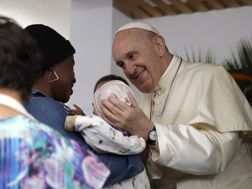 Pope Francis holds a baby during a visit to Zimpeto Hospital in Maputo.