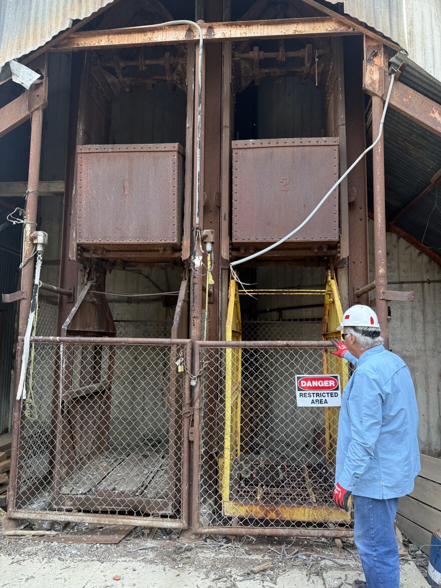 Career geologist Brian Buck now donates his time serving as project manager for Friends of Ski Mountain Mining History. Buck is standing near the cage that was once used to transport skiers from underground.