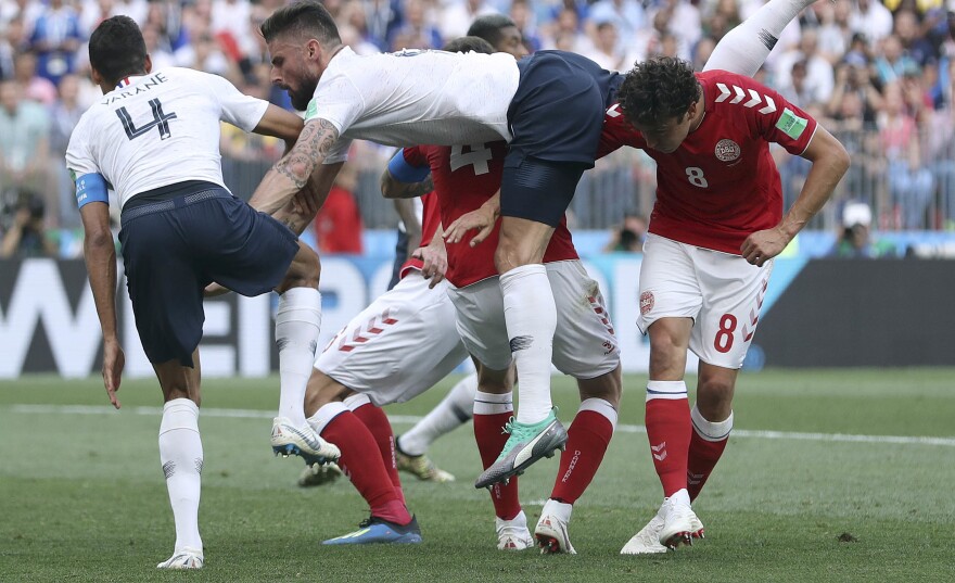 France's Olivier Giroud, center, goes down after a header during the group C match between Denmark and France at the 2018 soccer World Cup at Luzhniki Stadium in Moscow on Tuesday. The teams played to a scoreless tie — the tournament's first.