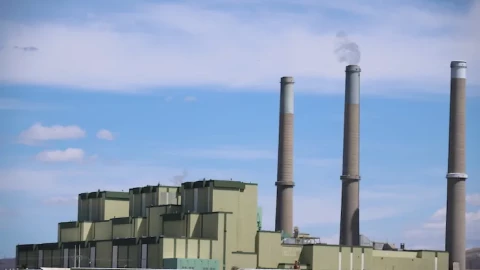 A large power plant with smoke stacks.