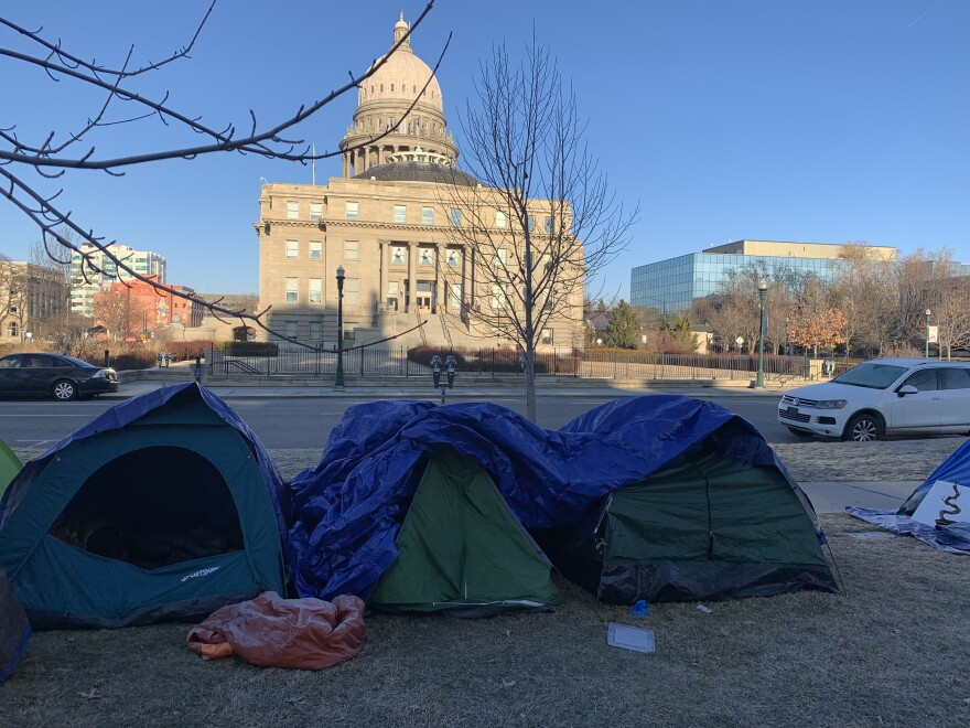 A photo of three tents on the grass with the Idaho Statehouse in the background. 