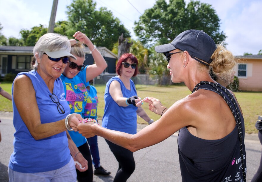 Lauren Book, right, founder of Lauren's Kids, passes out bracelets as part of the April 2025 Walk in My Shoes in Pensacola.