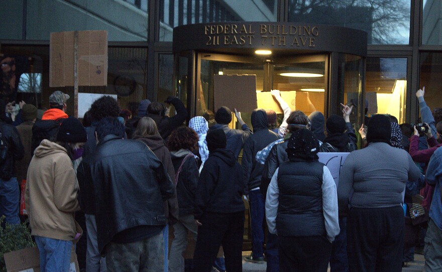 A crowd bangs on the doors of the Eugene Federal Building, Jan. 30, 2026.