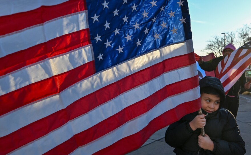 Amar Garcia holds an American Flag during a protest in Hazleton in support of immigrant families.
