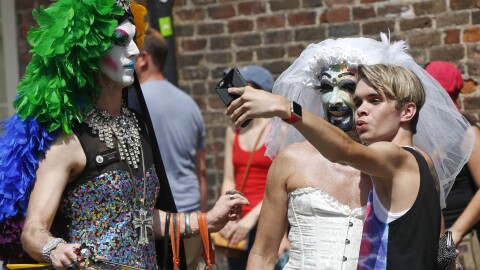 A reveler takes a selfie photo with costumed revelers during the "New Orleans Pride" block party, part of weekend gay pride festivities, in New Orleans, Sunday, June 19, 2016. (AP Photo/Gerald Herbert)