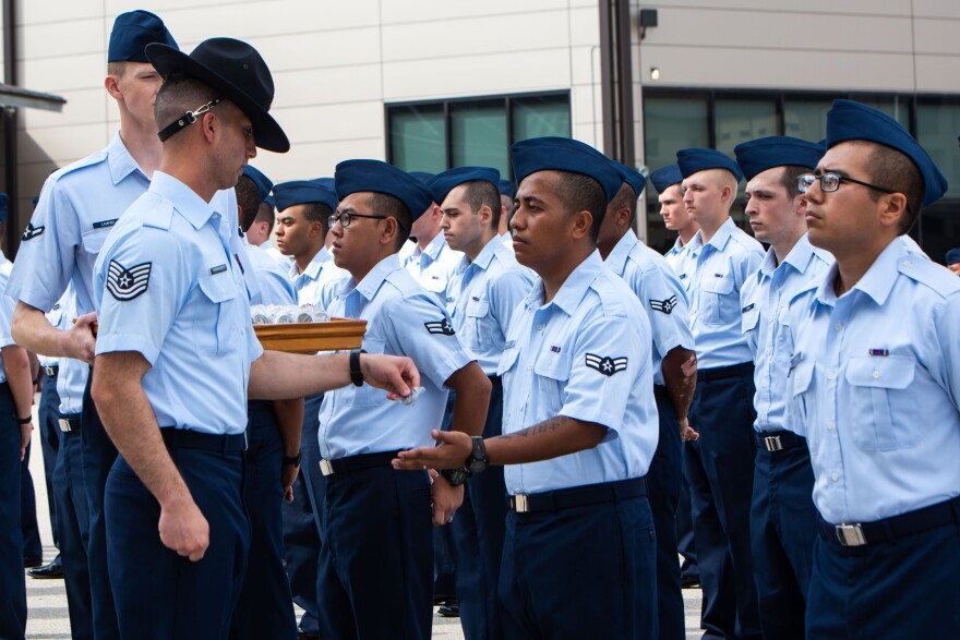 Airman 1st Class Joshua Garamfel, originally from Micronesia, is awarded an Airman's coin at the end of Basic Military Training at Joint Base San Antonio - Lackland on July 12. Garamfel was one of 18 new citizen-graduates.